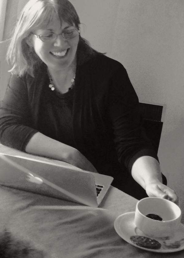 image of the author at her computer with a cup of coffee